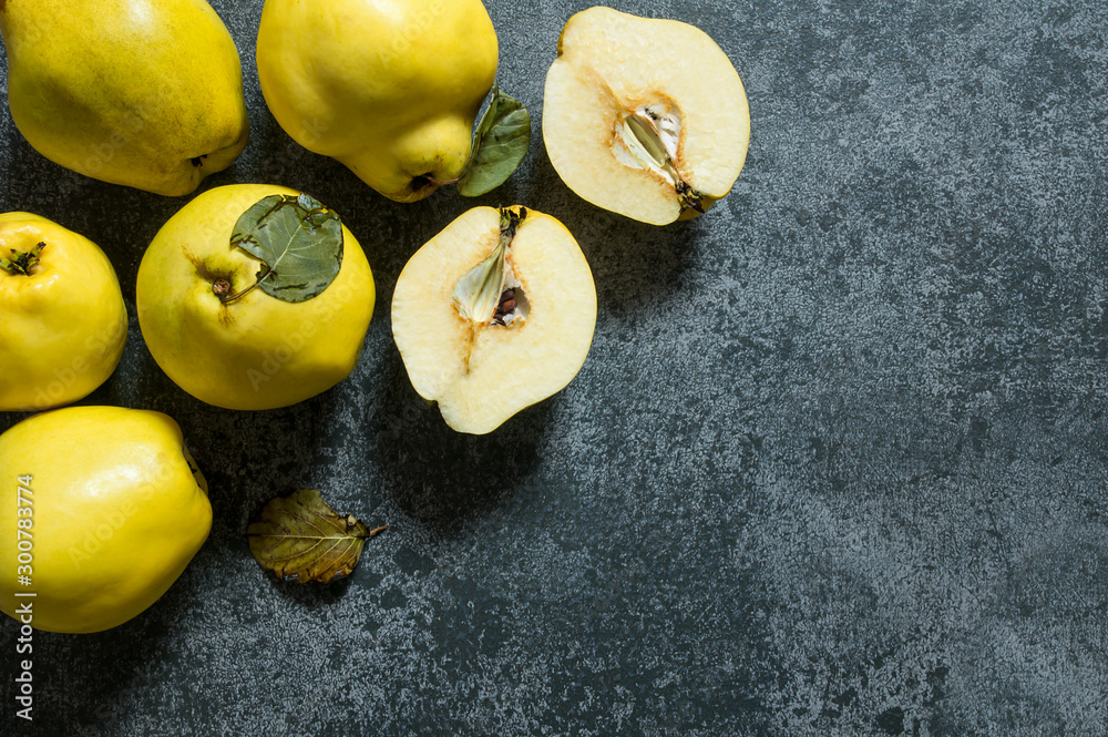Fresh ripe organic half and whole quinces on rustic background. Healthy yellow fruit quince, Cydonia oblonga