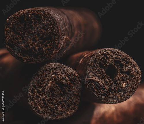 Canvas Print Three manly hand rolled havana cigars with shallow depth of field with dark backround