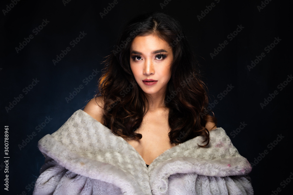 Sensual Look of Fashion Model High Make Up curl style hair Red Lips, Woman wear Fur and look at camera in beauty shot, studio lighting dark fog smoke background backlit light Sensual Look of Fashion Model High Make Up curl style hair Red Lips, Woman wear Fur and look at camera in beauty shot, studio lighting dark fog smoke background backlit light