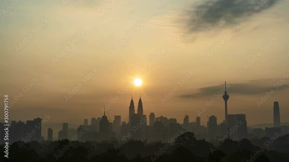 Stunning sun rising scene over iconic Kuala Lumpur buildings or landmarks, cityscape time lapse motion, moving clouds scenery at morning.