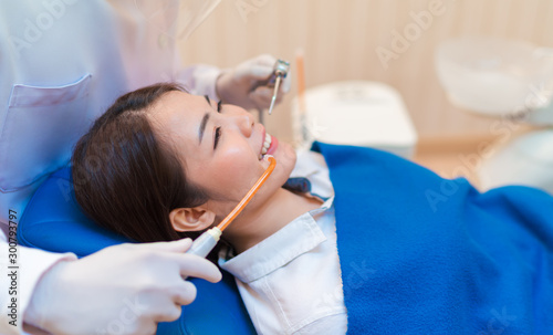 Closeup woman having dental teeth examined dentist check-up via excavator in Clinic her patient for beautiful smile
