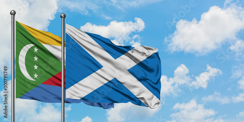 Comoros and Scotland flag waving in the wind against white cloudy blue sky together. Diplomacy concept, international relations.