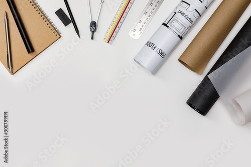 Top view workspace mockup of architectural project with laptop computer, architectural project plan, engineering tools and office supplies on white desk empty space for your text isolated on white