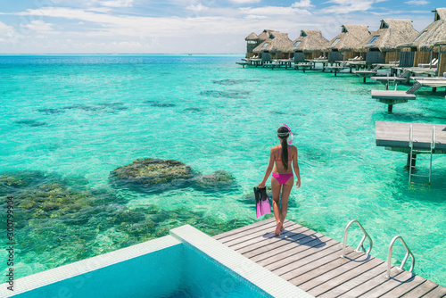 Obraz na płótnie Luxury overwater bungalows Tahiti resort woman going snorkeling from private hotel room on Bora Bora island, French Polynesia