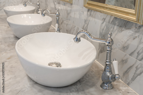 Beautiful vintage faucet with wash basin sink on marble counter bathroom interior retro style