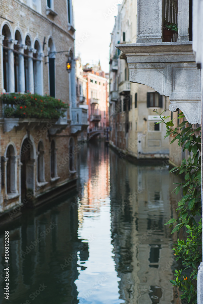 View of the canals and buildings of Venice. Beautiful historic brick buildings on the narrow streets and canals of the ancient city. Warm autumn day, travel to Italy.