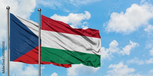 Czech Republic and Hungary flag waving in the wind against white cloudy blue sky together. Diplomacy concept, international relations.