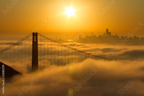Photo Spectacular Golden Gate Bridge sunrise with low fog and city view