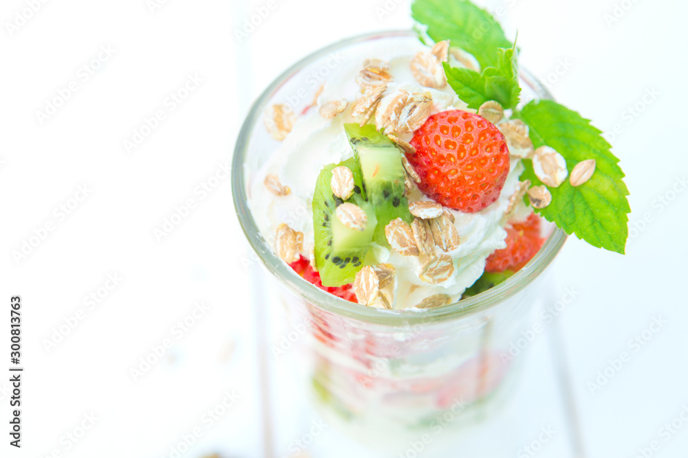 Dessert yogurt and strawberry in glass on white wooden background