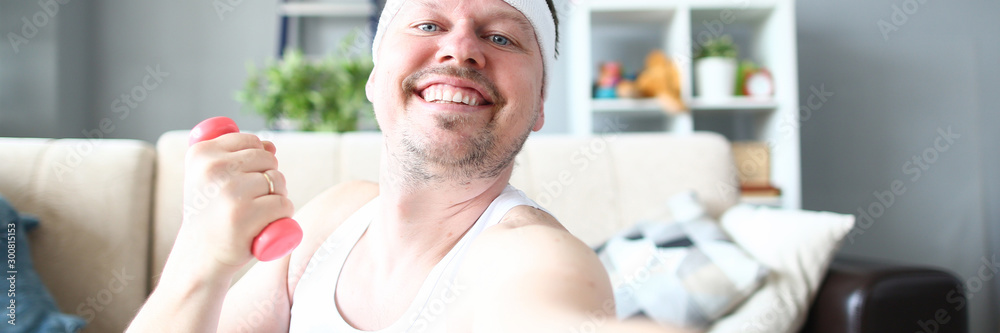 Obraz premium Cheerful Sportsman Doing Exercise with Dumbbell