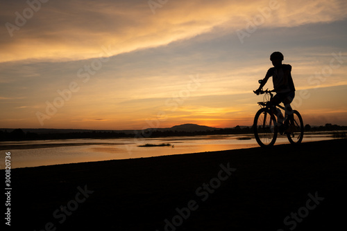 Asian men cycling bicycle on the road in the sunset time