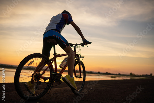 Men cycling bicycle on the road in the sunset time lifestyle of cyclist