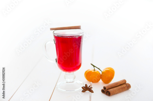 Mulled wine with cinnamon sticks on a white wooden background