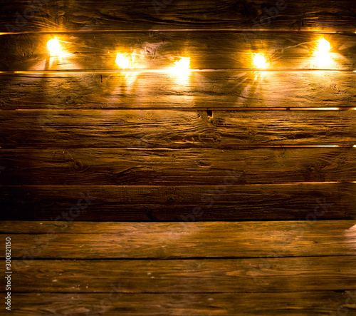 Christmas lights decoration on brown wooden background photo