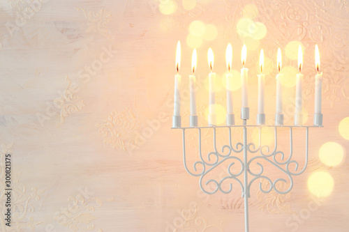 Religion image of jewish holiday Hanukkah background with menorah (traditional candelabra) and candles over white background