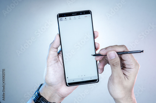 Man Holding New Samsung Galaxy Note 8 with S Pen to writing in the blank space.