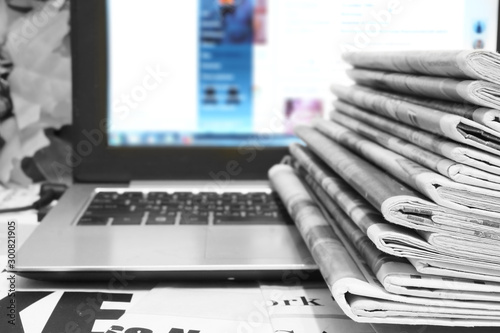 Newspapers and Laptop. Different Concepts for News - Social Network or Traditional Tabloid Journals. Data Sources - Electronic Screen of Computer or Paper Pages of Magazines, Internet or Papers  