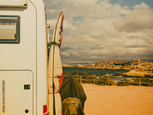 Camper car with surf board on beach