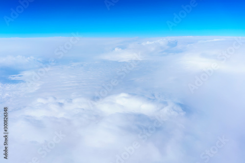 Aerial view from Airplane's window viewing white clouds and blue sky