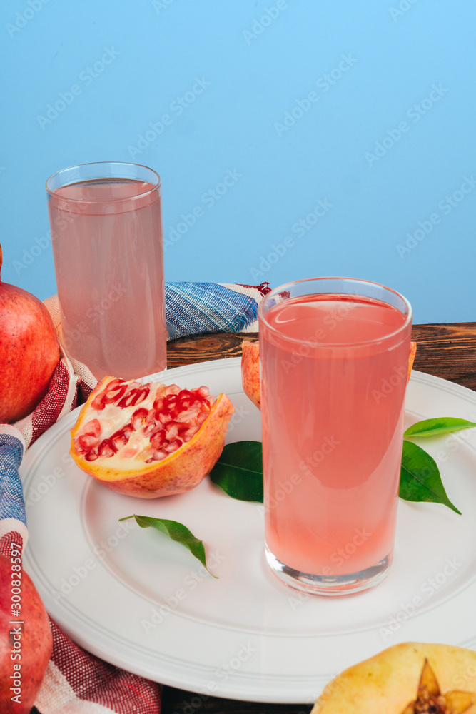 Glass of pomegranate juice and fruits on a table Glass of pomegranate juice and fruits on a table