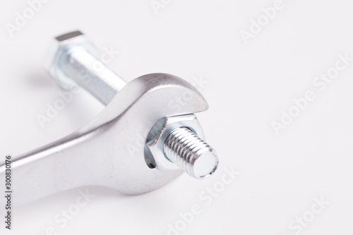 Wrench and bolt with nut close up. Wrenches on a white background.The bolt is unscrewed with a wrench. 