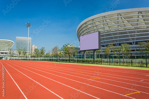 The sports playground in the park with artificial grass and a stretched net on a background of green trees
