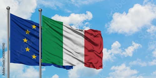 European Union and Italy flag waving in the wind against white cloudy blue sky together. Diplomacy concept, international relations.