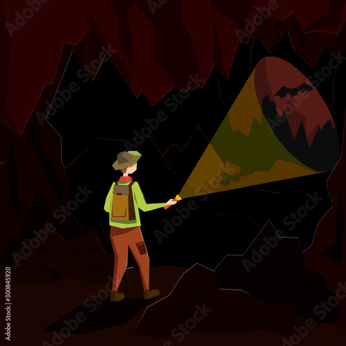 A young man stands in a dark cave and illuminates his path with a lantern. Illustration in a flat style.