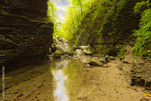 Picturesque pathway to the famous Kozjak Waterfall  Slap Kozjak . Narrow path with small bridge over river. Protected natural treasure. National Park of Triglav  Soca valley  Slovenia