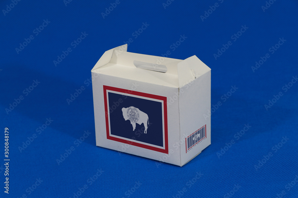 Wyoming flag on white box with barcode and the color of state flag on blue background. The concept of export trading from Wyoming.