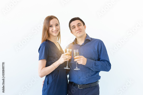 Man and woman celebrating Christmas or New Year eve party with glasses of champagne on white background