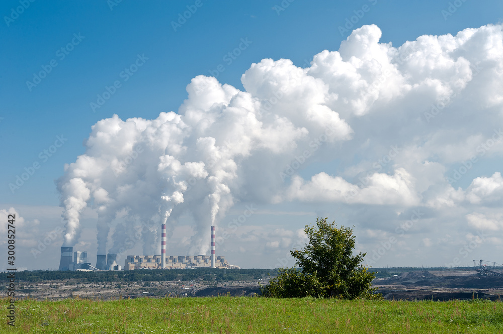 Coal-fired power station with steam billowing from high chimneys. Power plant in Bełchatów, Poland