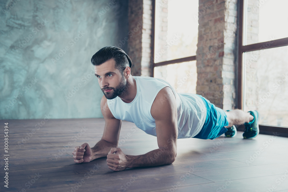Profile photo of macho sportsman guy doing plank on elbows hands leaning floor determined sportswear tank-top shorts sneakers training house studio windows indoors - obrazy, fototapety, plakaty 