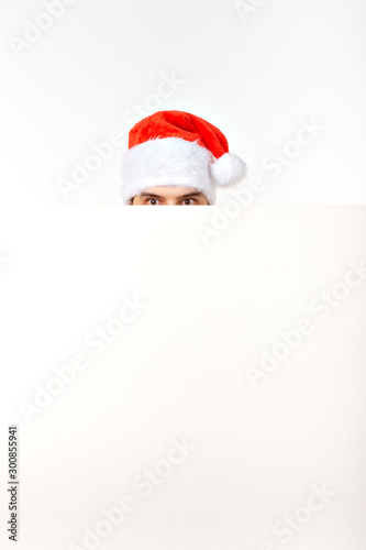 Santa man in christmas red hat for new year holiday with white paper sheet isolated on white background, copy space © satura_