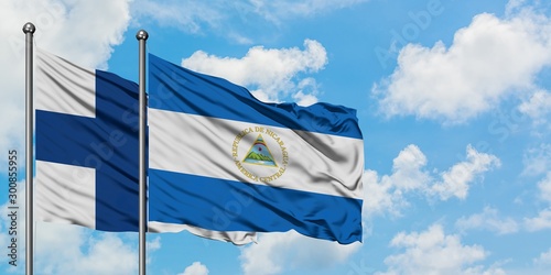 Finland and Nicaragua flag waving in the wind against white cloudy blue sky together. Diplomacy concept, international relations.