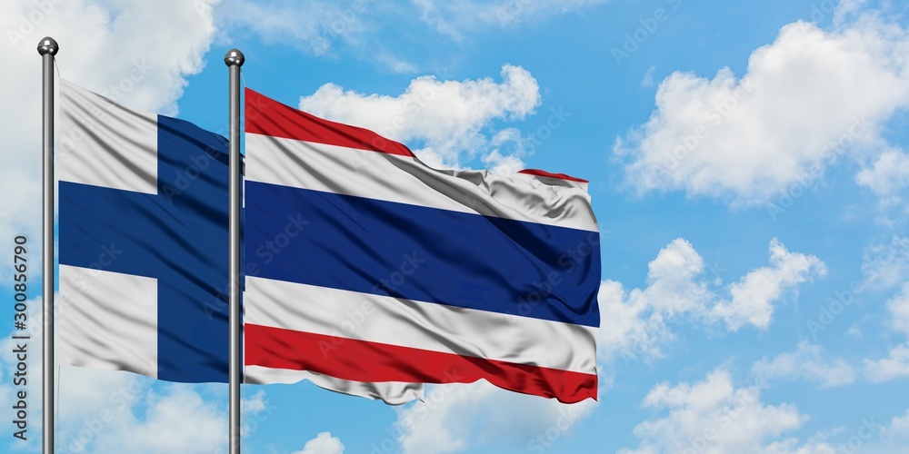 Finland and Thailand flag waving in the wind against white cloudy blue sky together. Diplomacy concept, international relations.