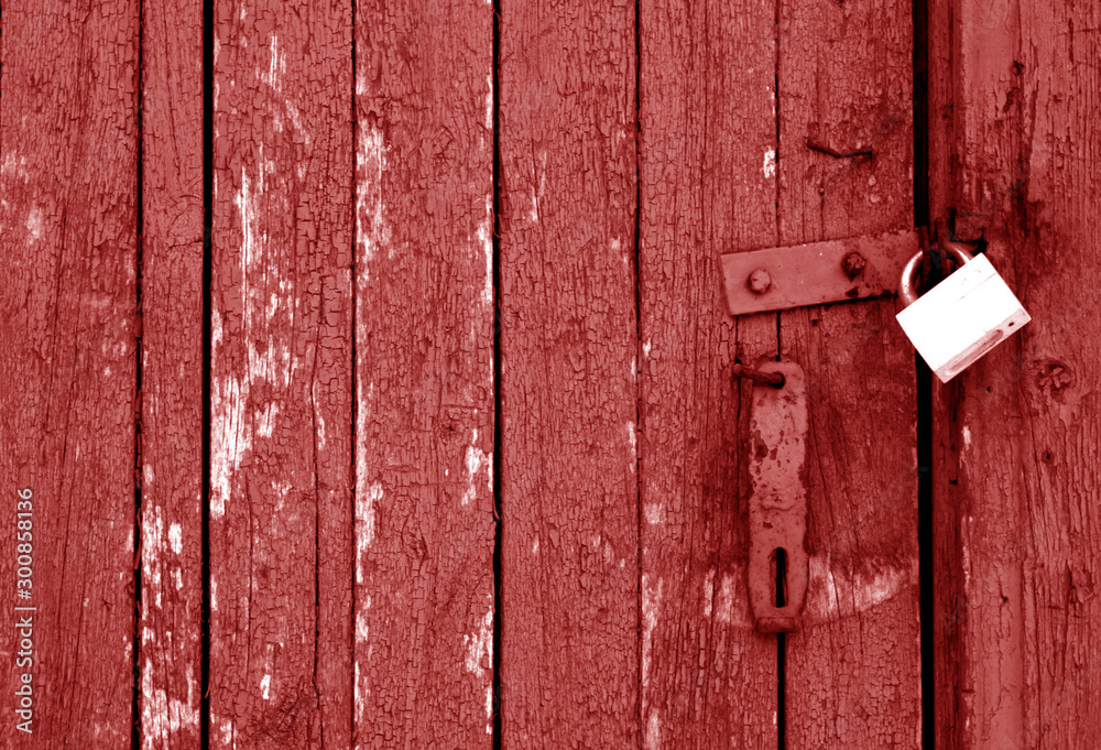 Grungy wooden door with lock in red tone.