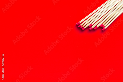 Symbol of danger with matches on red background top view copyspace