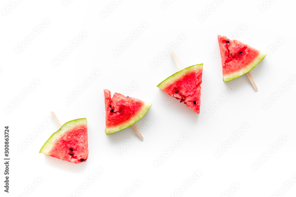 Cut watermelon on stick for break with fruit popsicle on white background top view Cut watermelon on stick for break with fruit popsicle on white background top view
