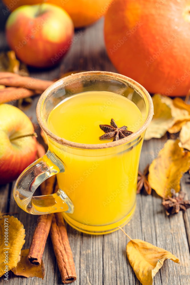 Autumn hot and spicy drink with pumpkin and orange juice on the rustic background. Selective focus. Shallow depth of field. Autumn hot and spicy drink with pumpkin and orange juice on the rustic background. Selective focus. Shallow depth of field.