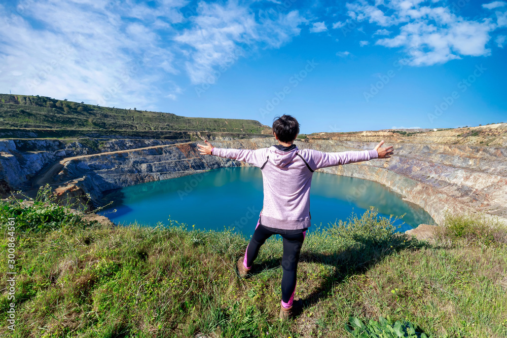 Woman traveling alone enjoying open pit mining landscape. Adventure trip lifestyle vacations weekend.