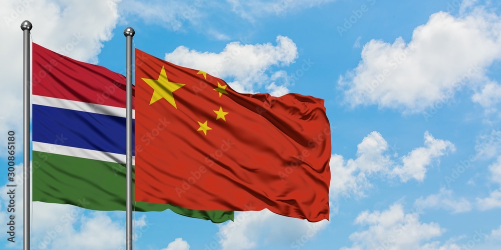 Gambia and China flag waving in the wind against white cloudy blue sky together. Diplomacy concept, international relations.