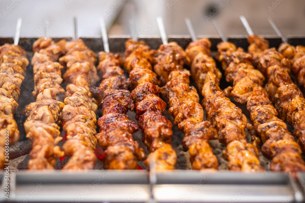 Chicken kebabs cooking on a charcoal grill at Christmas market winter wonderland in London