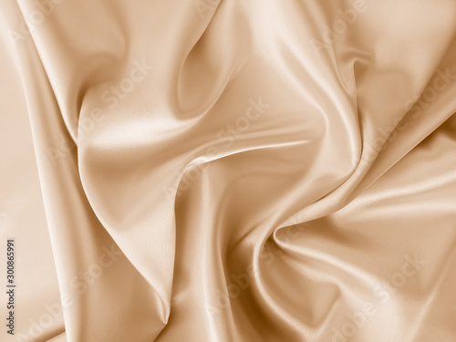 Beautiful smooth elegant wavy beige / light brown satin silk luxury cloth fabric texture, abstract background design. Copy space. photo