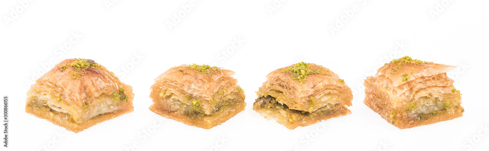 traditional turkish honey baklava with nuts in row isolated on white, panoramic shot traditional turkish honey baklava with nuts in row isolated on white, panoramic shot