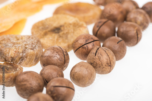 close up view of dried mango slices, figs and macadamia nuts isolated on white