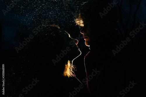 Loving couple silhouette. Back light and spray.