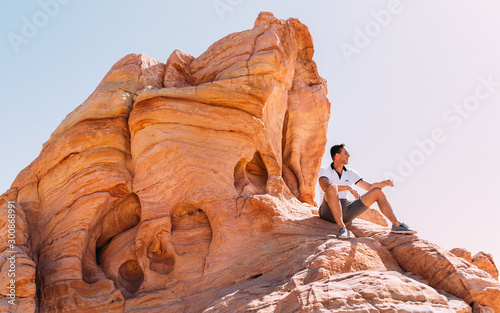 Junger Mann auf roten Felsen im Valley of Fire in Nevada USA