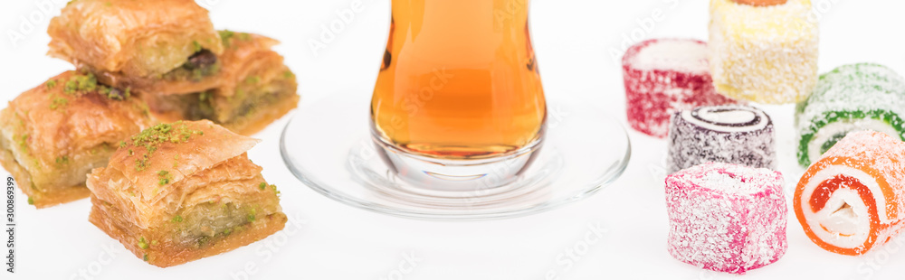 cup of tea near baklava, turkish delight isolated on white, panoramic shot cup of tea near baklava, turkish delight isolated on white, panoramic shot