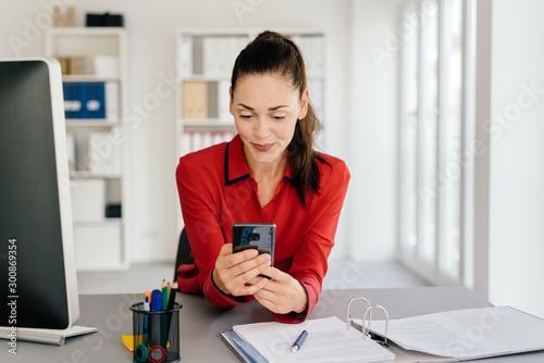 Картината върху платно Attractive businesswoman checking her mobile